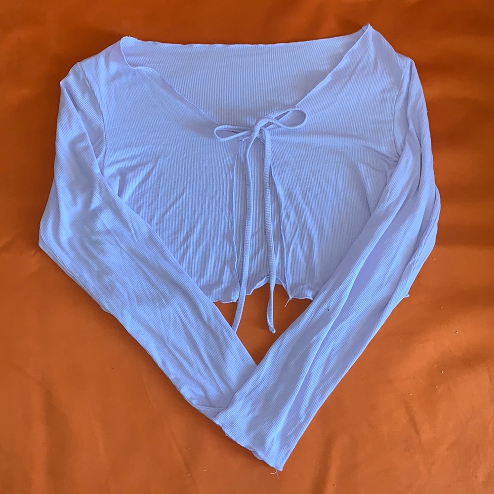 Light purple. Cropped long sleeve with a tie in the front size medium.